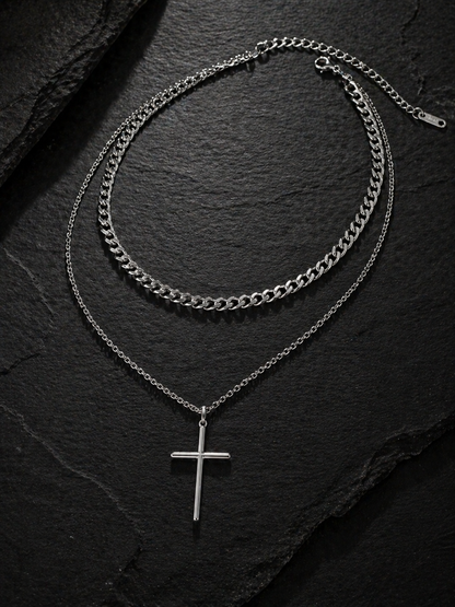 Two silver chain necklaces on a dark stone surface
