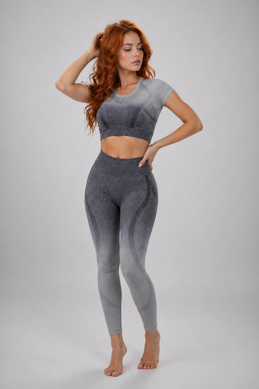 Woman wearing a gray athletic outfit on a plain background