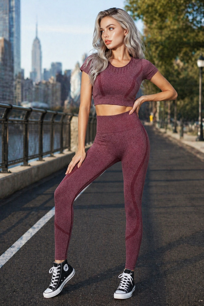 Woman in maroon athletic outfit standing on a city street with skyline in the background