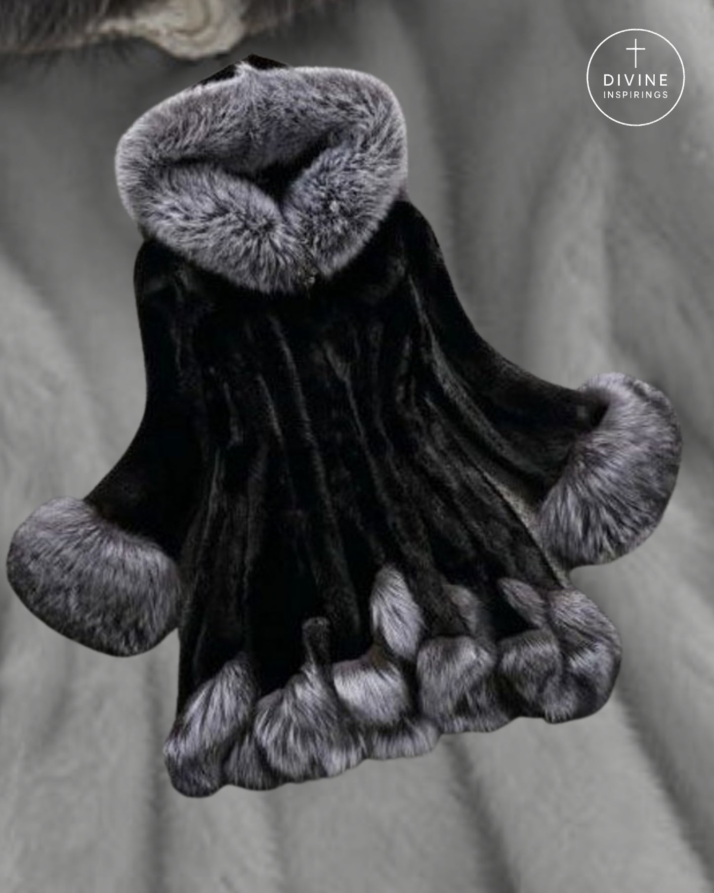 A black fur-trimmed religious habit or cloak with gray fur trim on the collar, cuffs, and hem, shown against a gray fabric background. A circular 'DIVINE INSPIRATION' logo is visible in the top right corner.