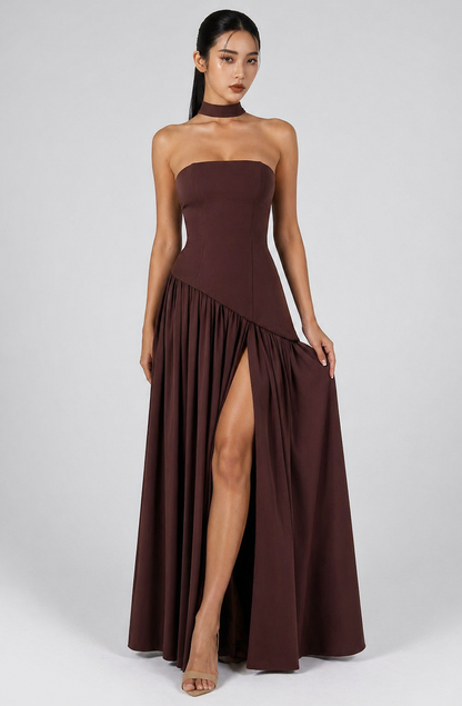 Woman wearing a strapless brown dress with a high slit on a white background