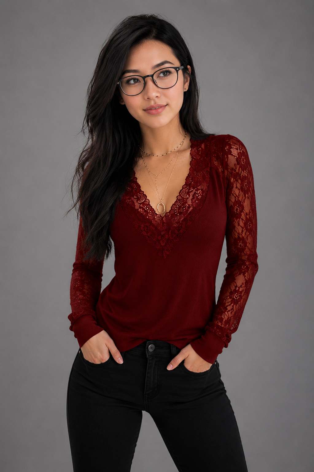 Woman wearing a red lace top against a gray background