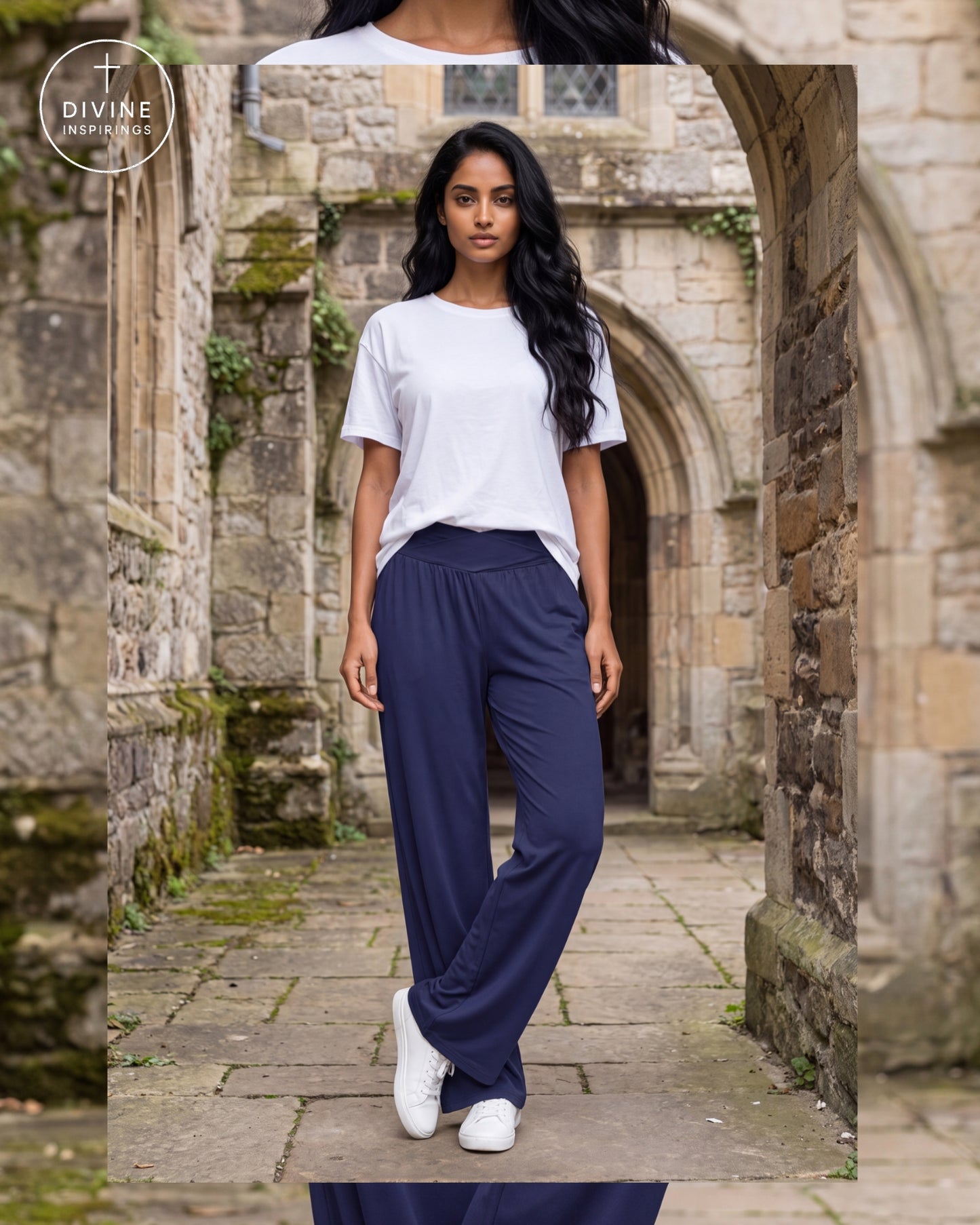 A woman stands in a stone courtyard wearing a white short-sleeve T-shirt, loose navy wide-leg pants, and white sneakers. A circular 'Divine Inspirings' logo appears in the upper left corner.
