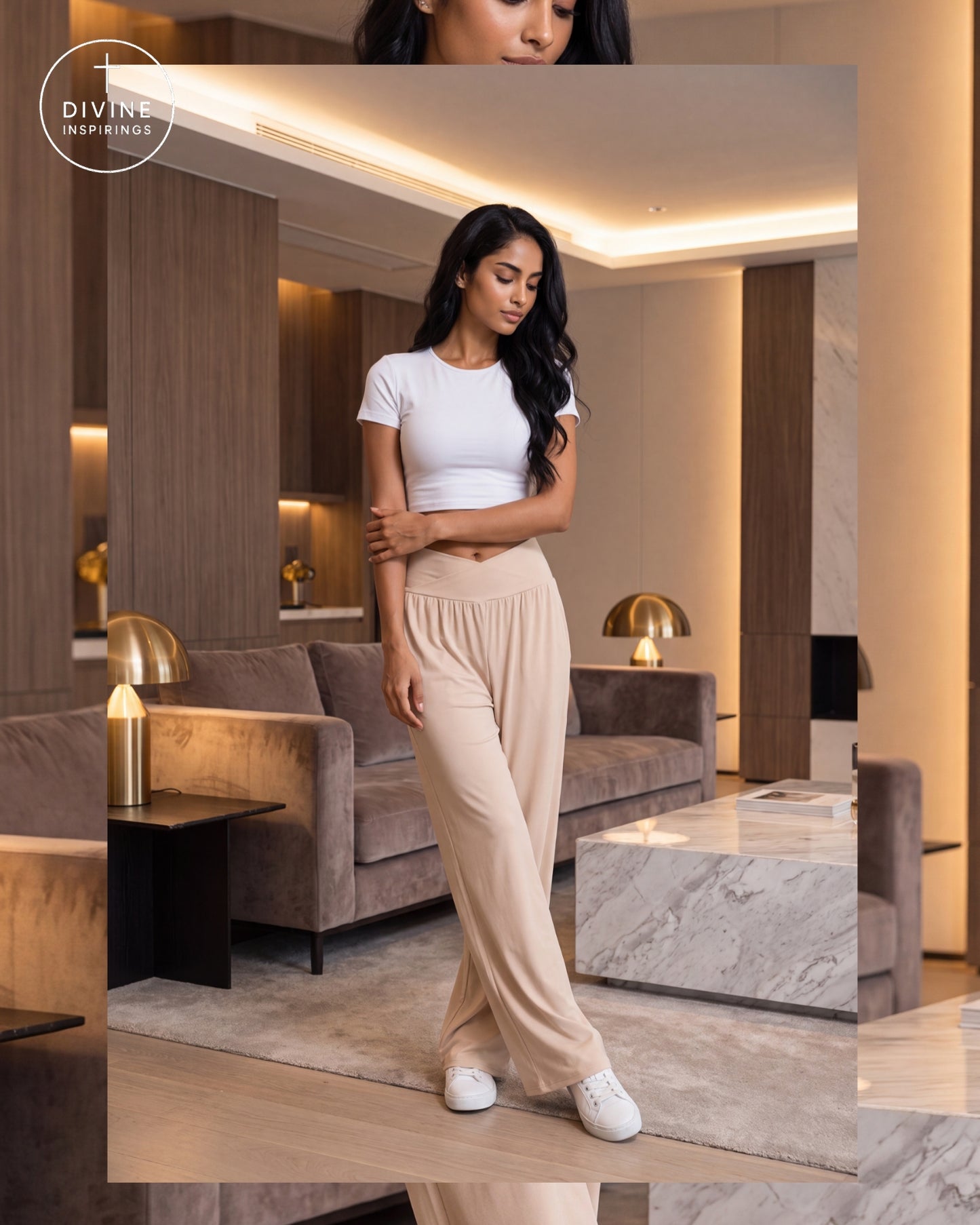 A woman modeling a white short-sleeve crop top and beige high-waisted wide-leg pants in a modern living room setting. The brand logo 'Divine Inspirings' is visible in the top left corner.