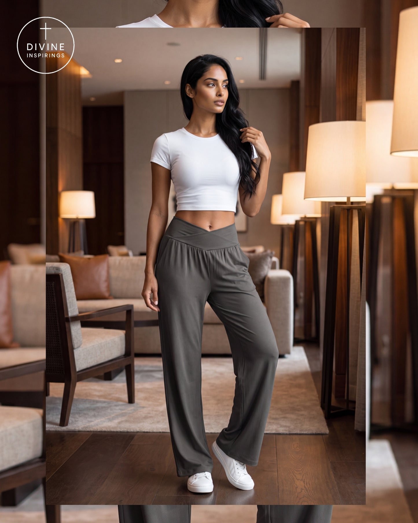 A woman models a two-piece activewear set consisting of a white short-sleeve crop top and high-waisted, wide-leg gray pants, standing in a modern, warmly lit living room. The Divine Inspirings logo is visible in the top-left corner.