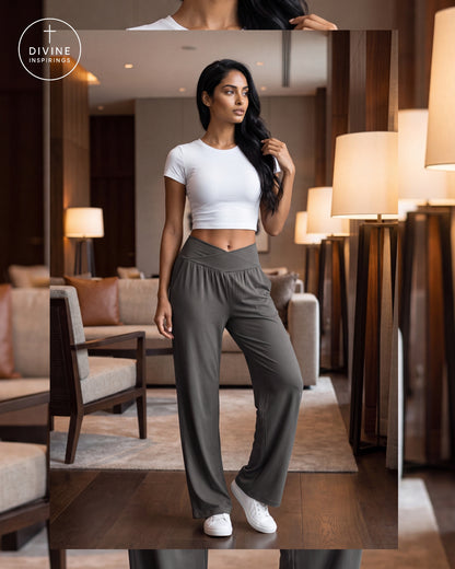 A woman models a two-piece activewear set consisting of a white short-sleeve crop top and high-waisted, wide-leg gray pants, standing in a modern, warmly lit living room. The Divine Inspirings logo is visible in the top-left corner.