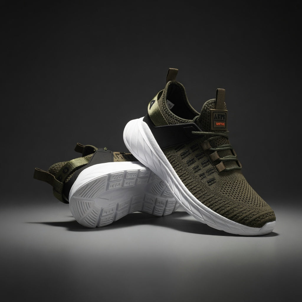 Green sneakers with white soles on a dark background