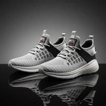 Gray athletic shoes with a reflective surface on a dark background