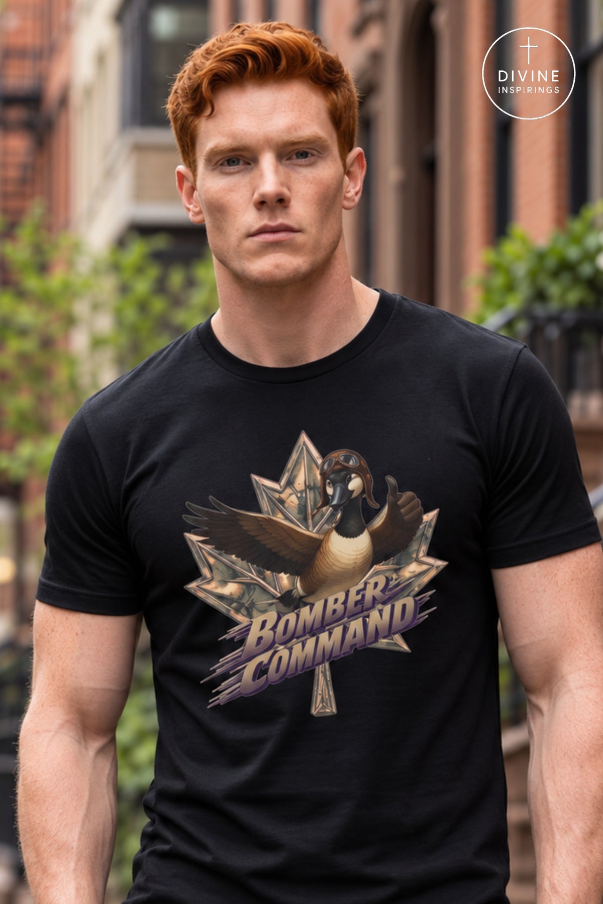 A man wearing a black t-shirt with a graphic of a goose inside a star and the text 'BOMBER COMMAND' in purple and gold. The background is a blurred outdoor street scene, and a 'DIVINE Divine Inspirings ' logo is visible in the top right corner.