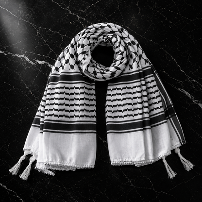 Black and white patterned scarf with tassels on a dark textured background