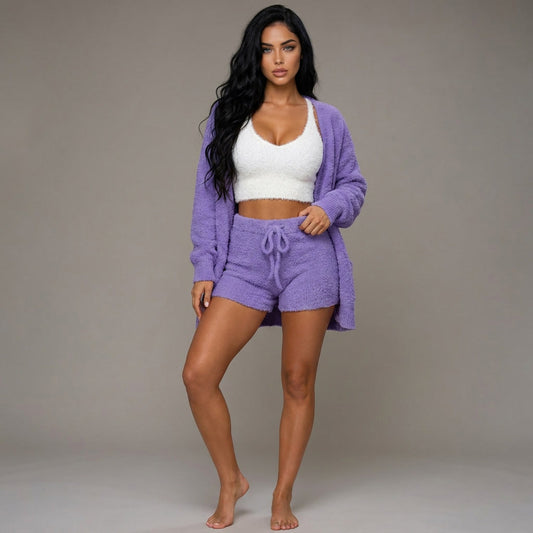 Woman wearing a purple loungewear set with a white top against a neutral background