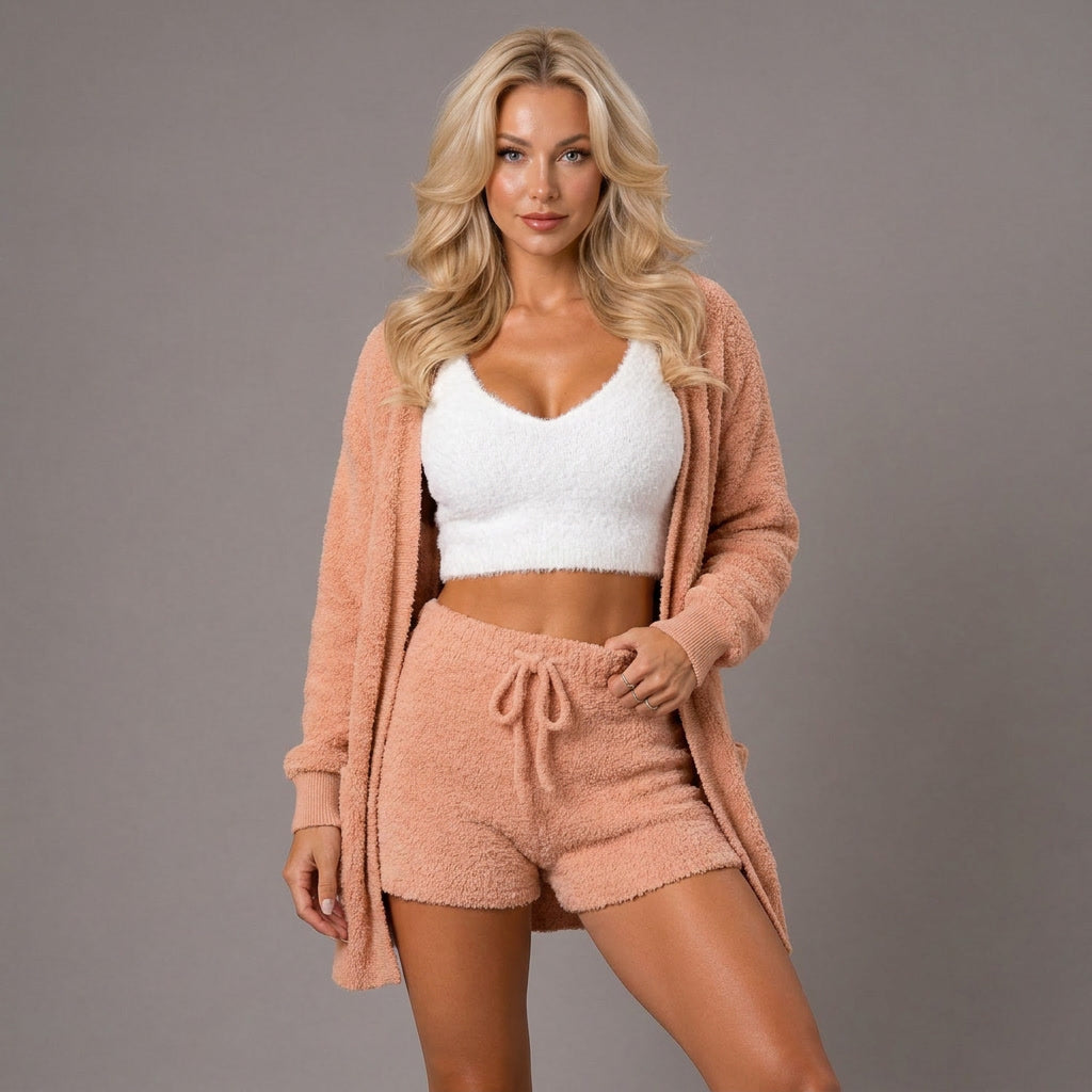 Woman wearing a pink loungewear set with a white top against a gray background