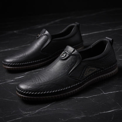 Pair of black leather shoes on a dark textured surface
