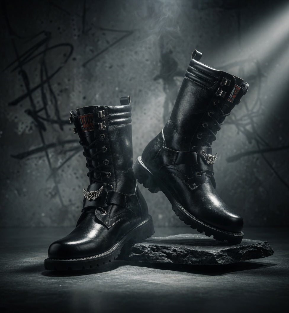 Pair of black leather boots with metal accents on a dark background