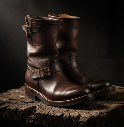 Pair of brown leather boots with buckles on a dark background