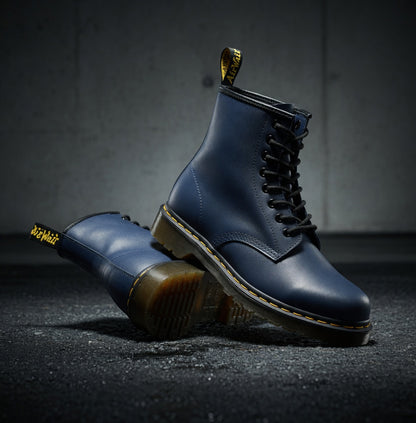 Blue leather boots with gold accents on a dark surface