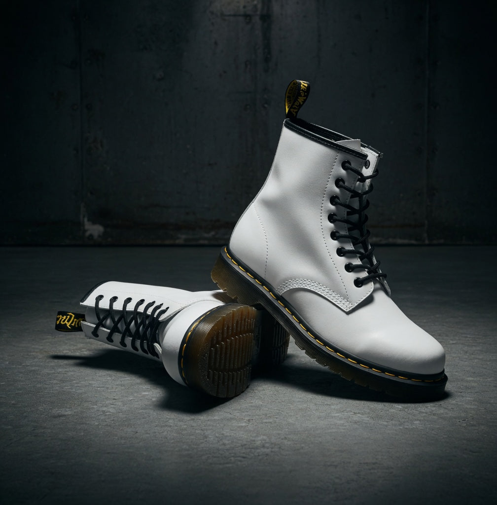 White boots with black soles on a dark surface