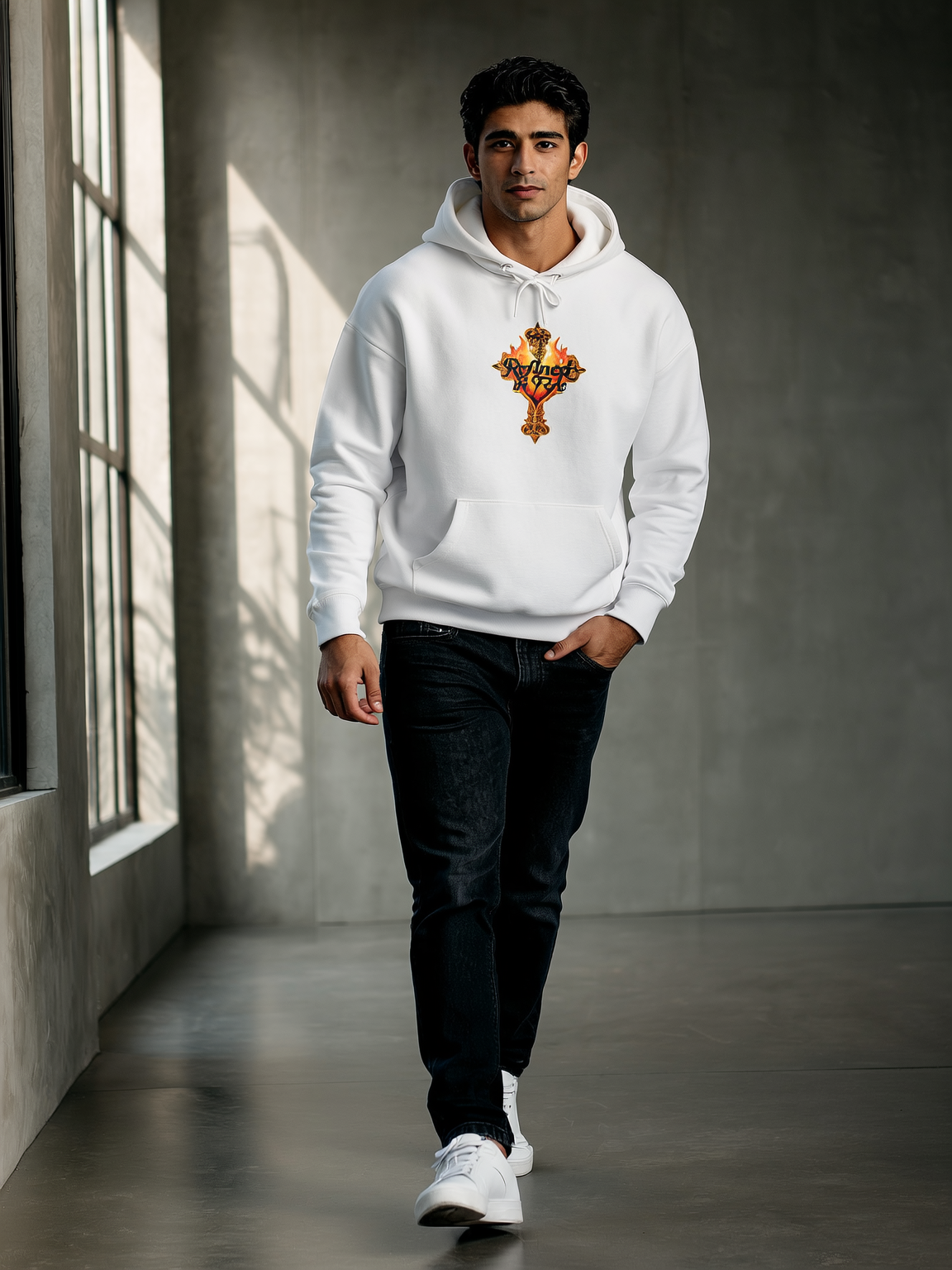 Man wearing a white hoodie with a colorful design walking in a room with large windows.