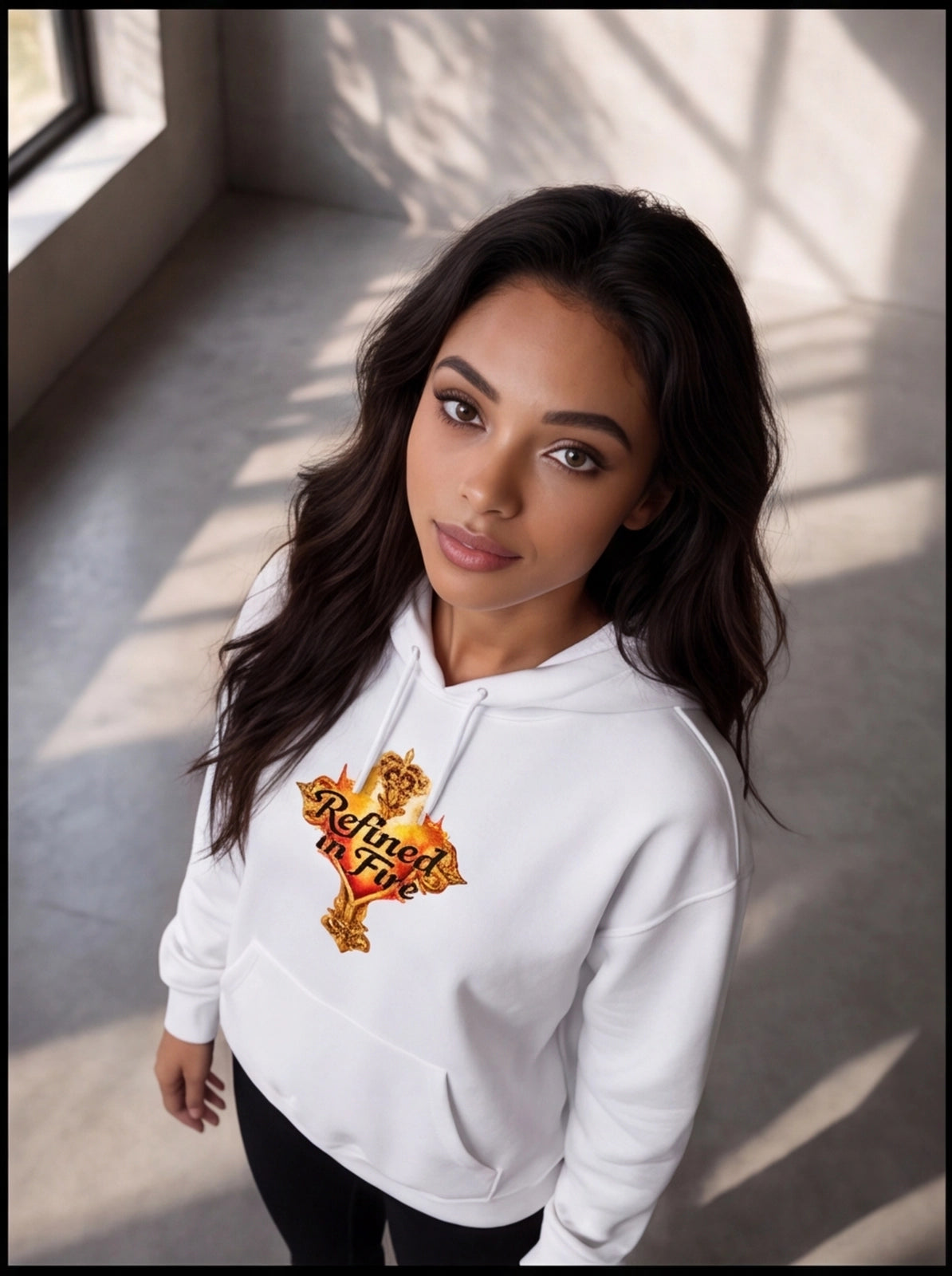 Woman wearing a white hoodie with a logo in a well-lit room