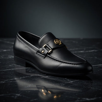 Black leather loafer with gold buckle on a dark surface