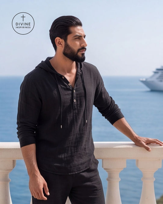 A man wearing a black long-sleeve henley hoodie stands on a balcony overlooking the ocean, with a cruise ship visible in the distance. The Divine Inspirings logo is in the top-left corner.