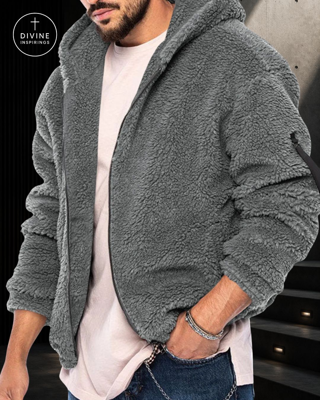 A man wearing a gray sherpa fleece zip-up hoodie over a light pink t-shirt and blue jeans, with a 'DIVINE INSPIRINGS' logo in the top-left corner.
