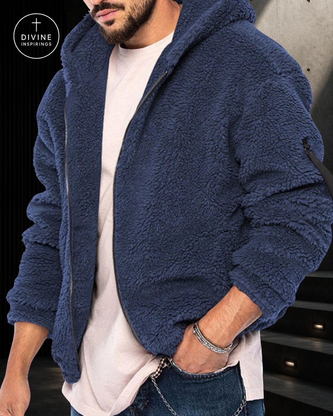 A man wearing a navy blue sherpa fleece zip-up hoodie over a white t-shirt and jeans, with a DIVINE INSPIRINGS logo in the top-left corner.