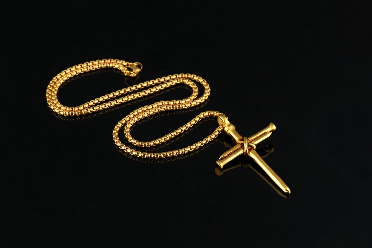 Gold chain with a cross pendant on a black background