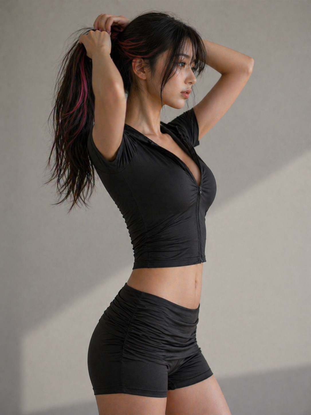 Woman in black athletic wear posing against a neutral background