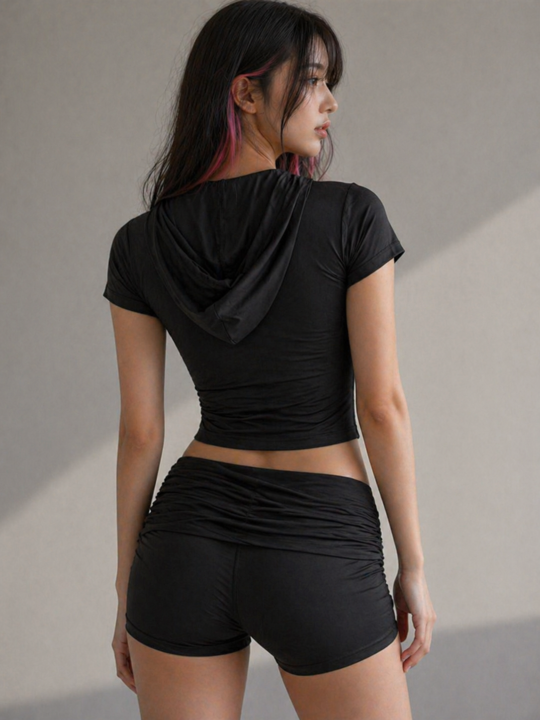 Woman wearing a black athletic outfit against a neutral background