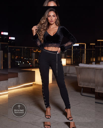 A woman models a black velvet long-sleeve crop top with lace trim and matching black lace-up skinny pants on a rooftop patio at night. The brand logo 'Divine Inspirings' is visible in the bottom left corner.