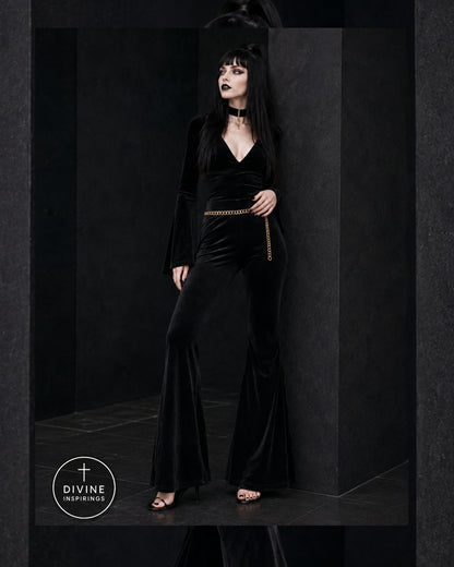 A gothic-style model with long black hair and pale makeup wears a black velvet top and pants with a thin gold chain belt. She is posed in a dark, minimalist studio setting with a 'DIVINE INSPIRINGS' logo in the bottom-left corner.