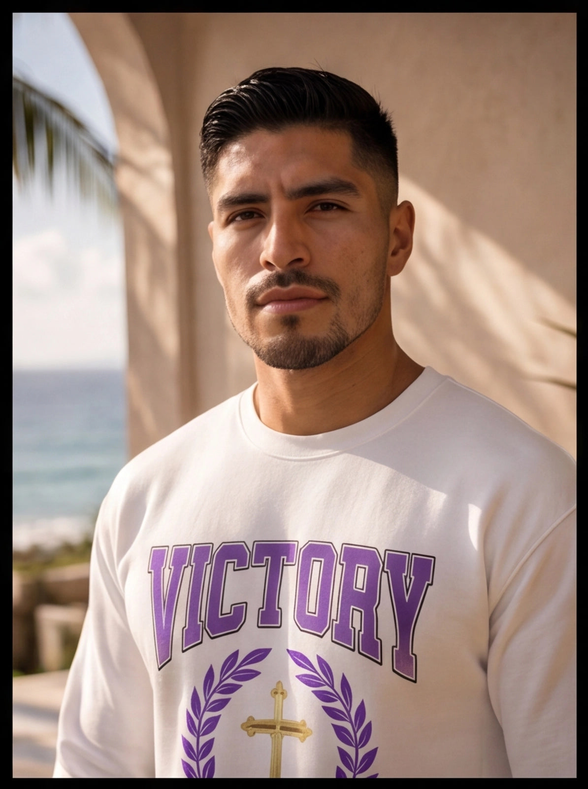 Man wearing a white sweatshirt with 'VICTORY' printed on it, standing outdoors.