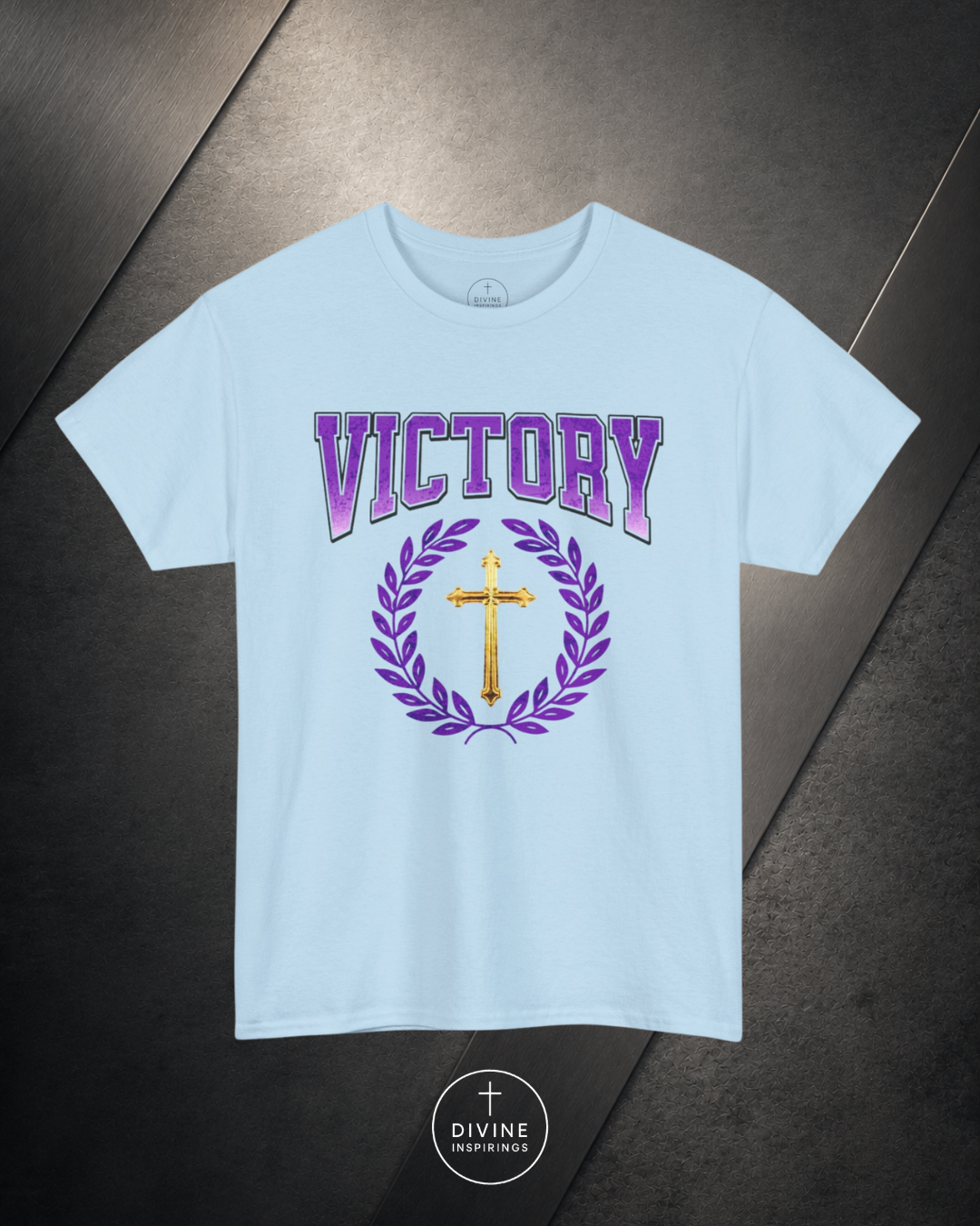 Light blue t-shirt with 'Victory' and cross design on a dark surface
