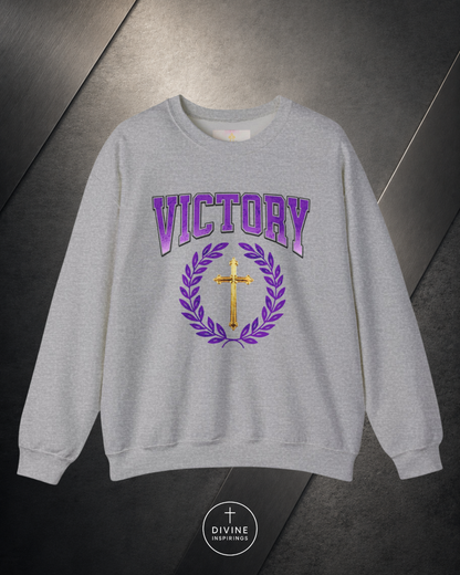 Gray sweatshirt with 'VICTORY' and cross design on a metallic surface, featuring the brand 'Divine Emporium'.
