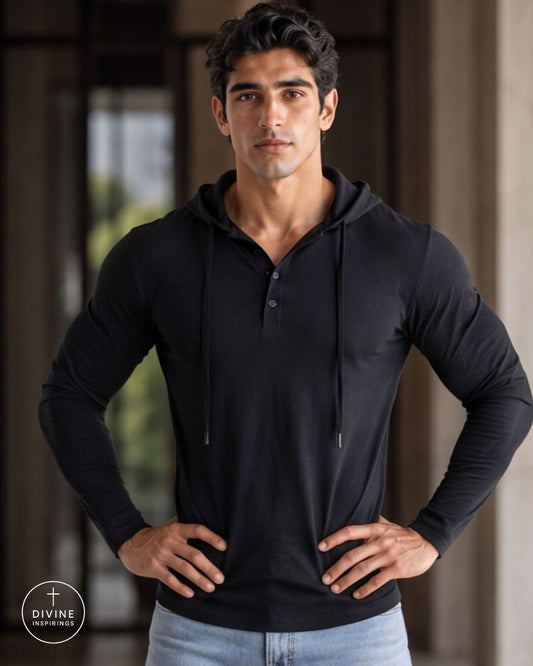 A muscular man wearing a black long-sleeve henley hoodie with a buttoned placket and drawstrings, posing with hands on hips. The Divine Inspirations logo is visible in the bottom-left corner.