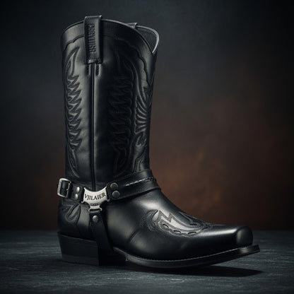 Black cowboy boot with intricate designs on a dark background
