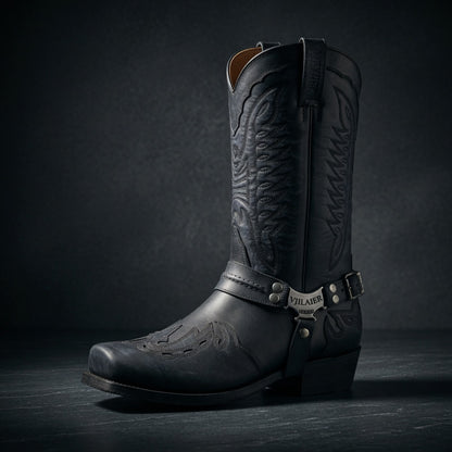 Black cowboy boot with detailed design on a dark background