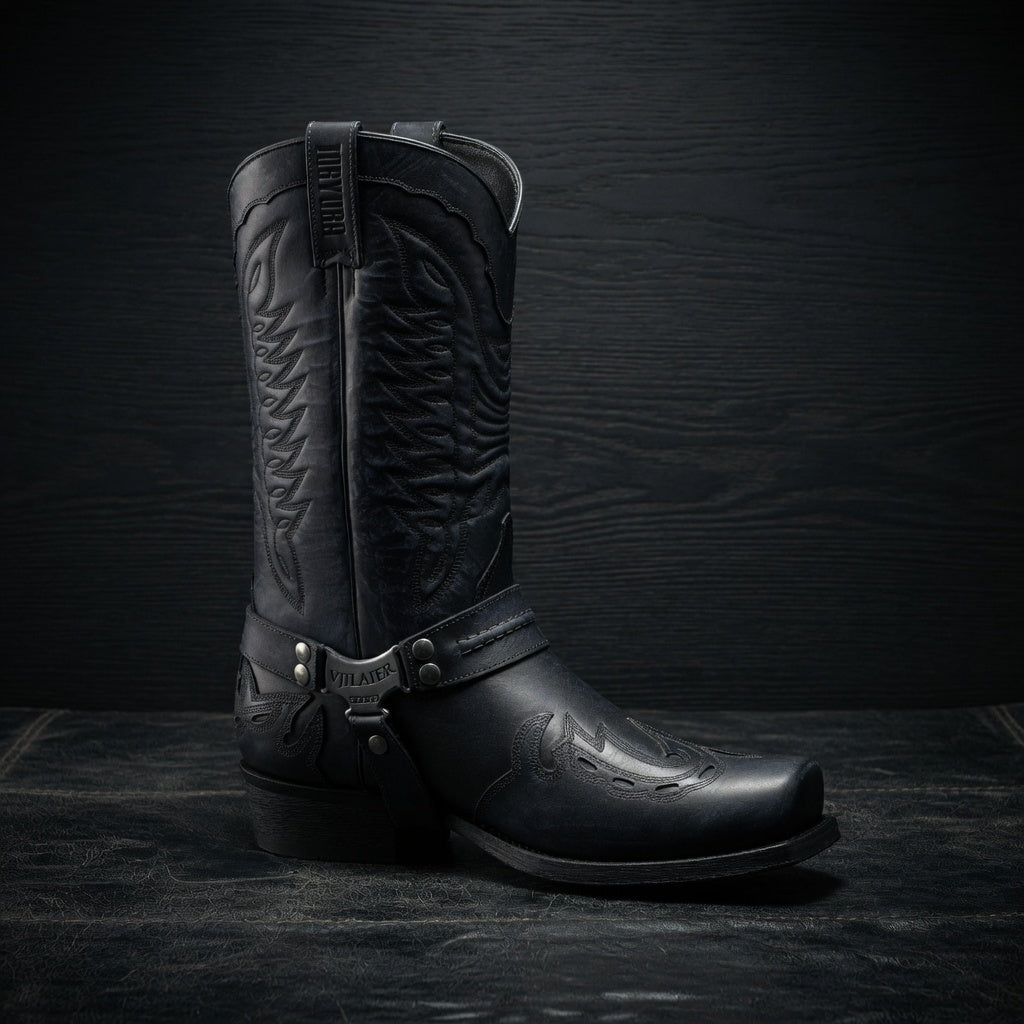 Black leather cowboy boot on a dark textured background