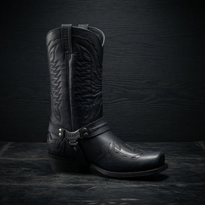 Black leather cowboy boot on a dark textured background