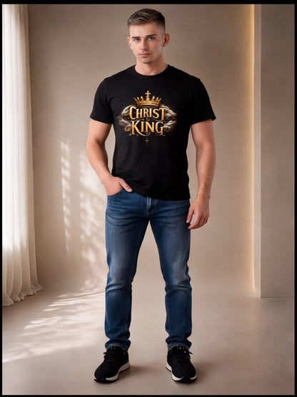 Man wearing a black t-shirt with 'Christ King' text and blue jeans in a softly lit room.
