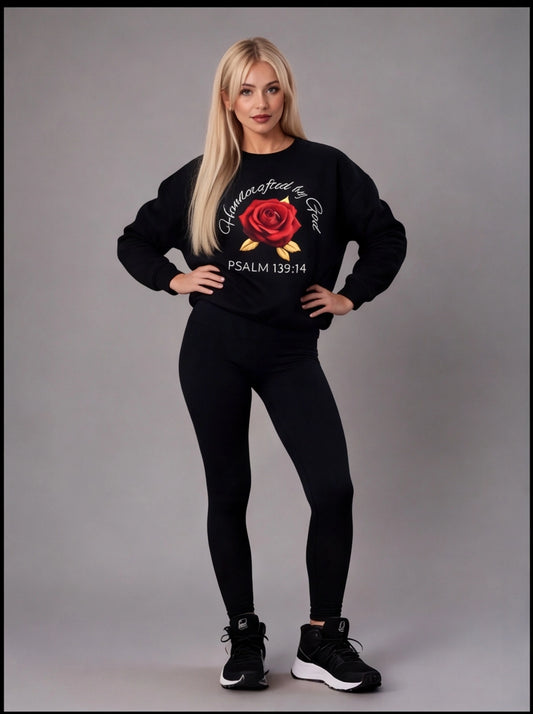 Woman wearing a black sweatshirt with a red rose design and text on a gray background