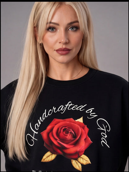 Woman wearing a black sweatshirt with a red rose and text design on a gray background