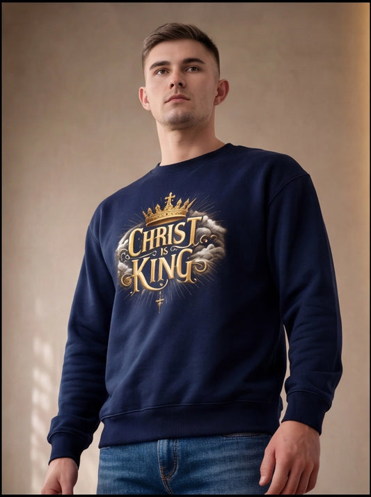 Man wearing a navy blue sweatshirt with 'Christ is King' text and crown graphic against a beige background