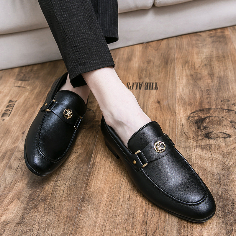 Black leather loafers worn on a wooden floor