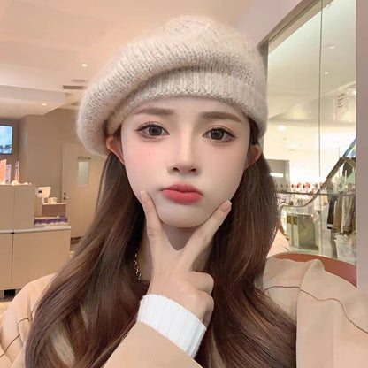 Person wearing a beige beret and coat indoors