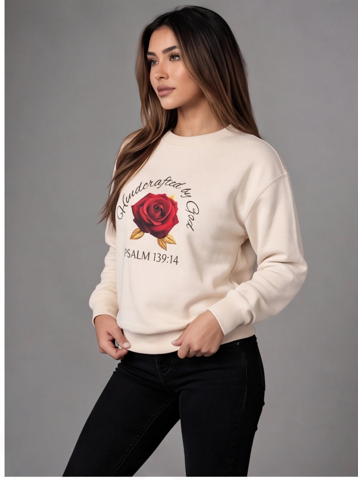 Woman wearing a cream sweater with a rose design and text on a gray background