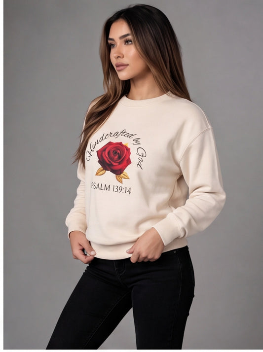 Woman wearing a cream sweater with a rose design and text on a gray background
