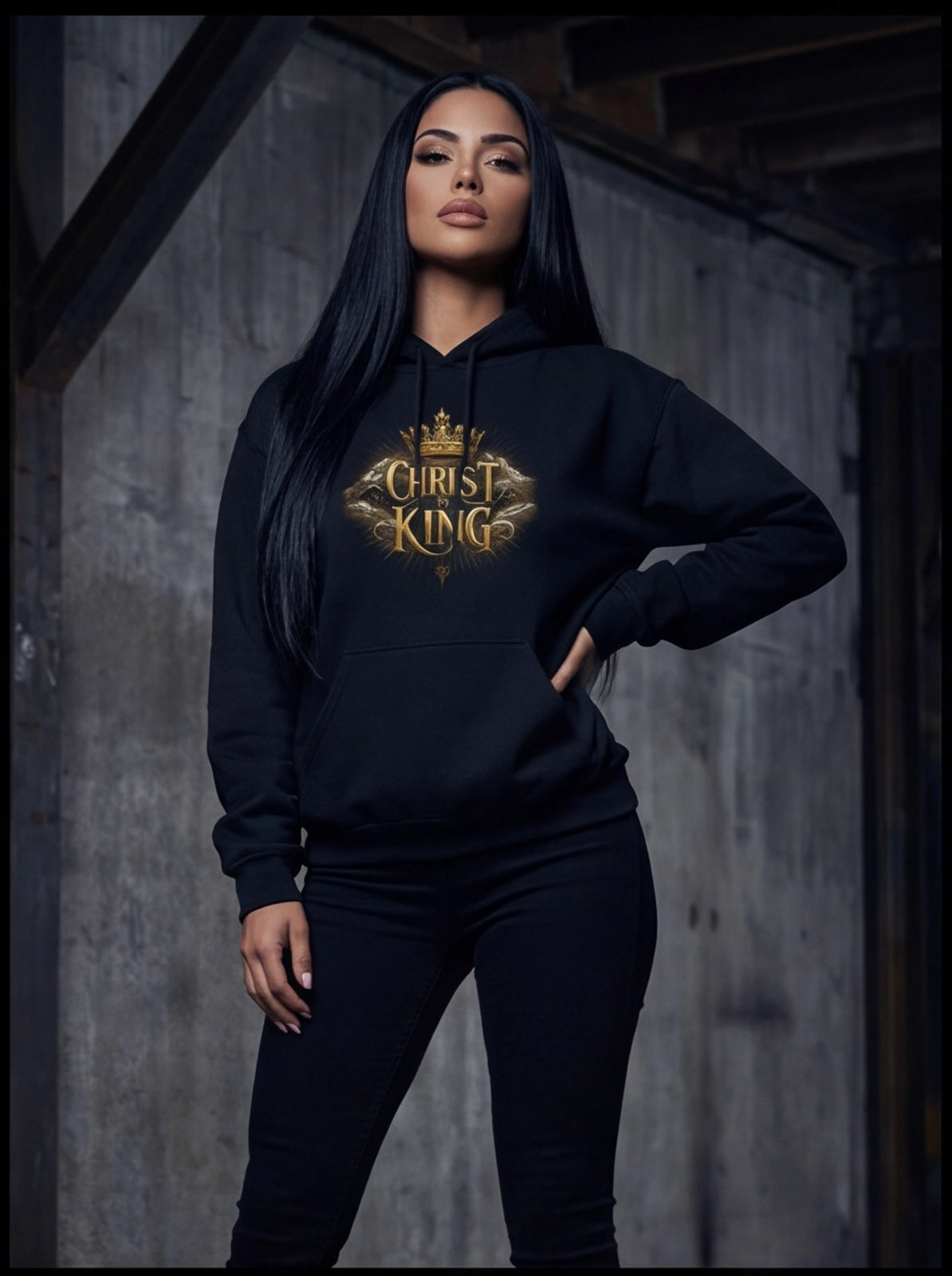 Person wearing a black hoodie with 'Christ King' text in gold, standing against a wooden wall.