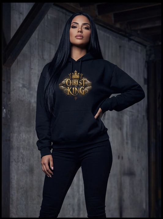 Person wearing a black hoodie with 'Christ King' text in gold, standing against a wooden wall.
